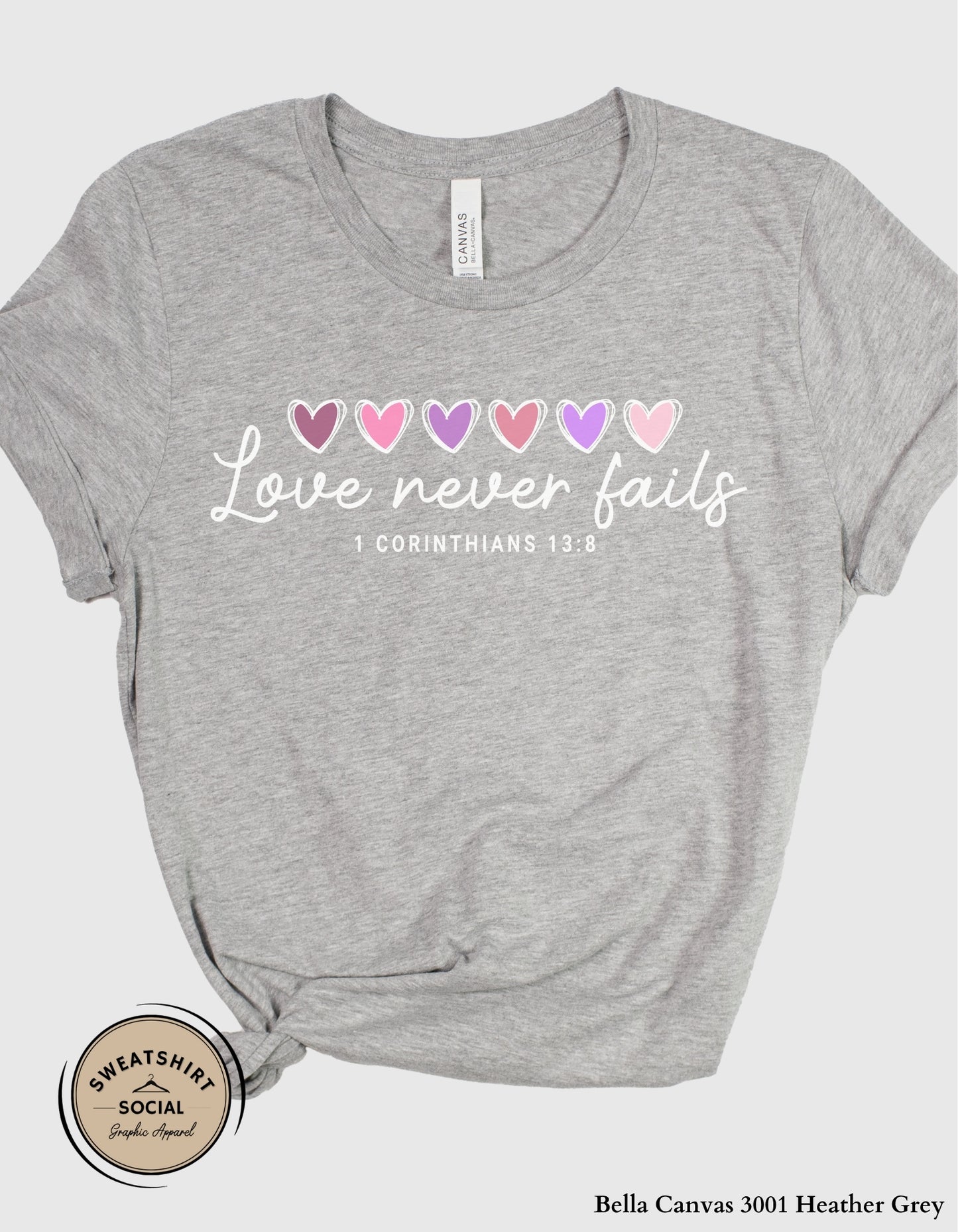 Love Never Fails White Valentine Shirt – 1 Corinthians 13:8 Heart Design (Adult Sizes S–2XL)